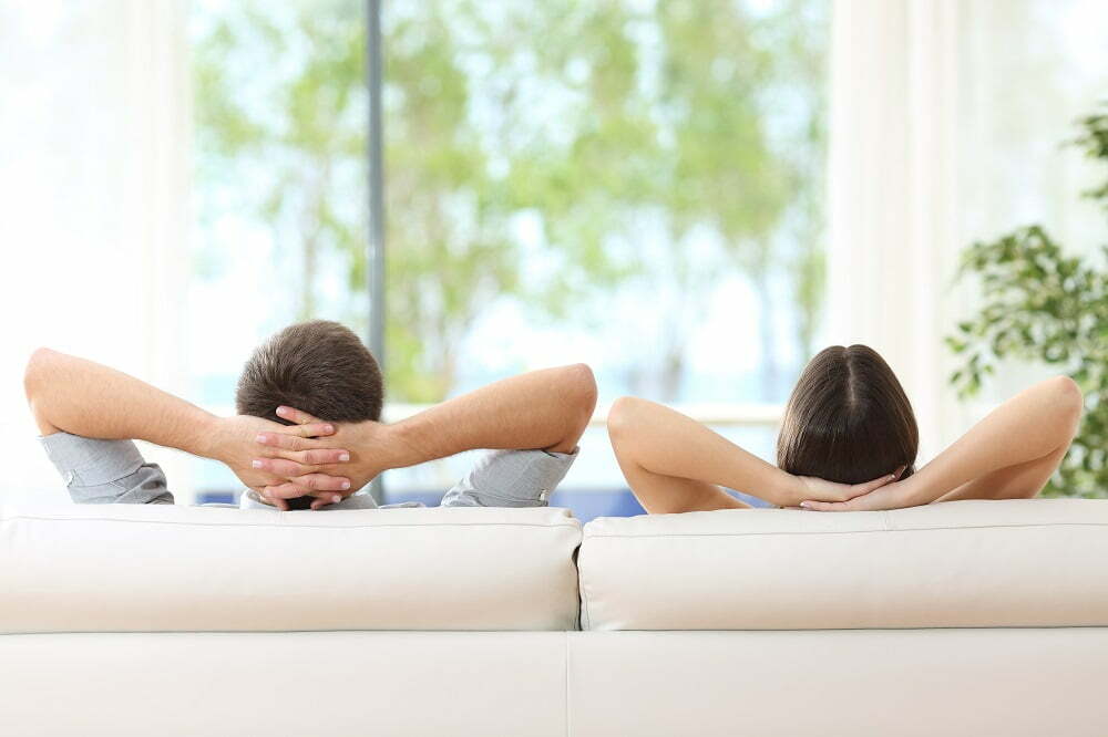 Kaksi ihmistä istuu sohvalla ja katselee ulos jutussa kodin viilennys.