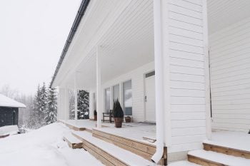 Unelmien koti ulkoapäin: valkoinen talo lumen keskellä