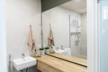 Kylpyhuoneen suuri peili ja puinen taso jutussa Unelmien koti.