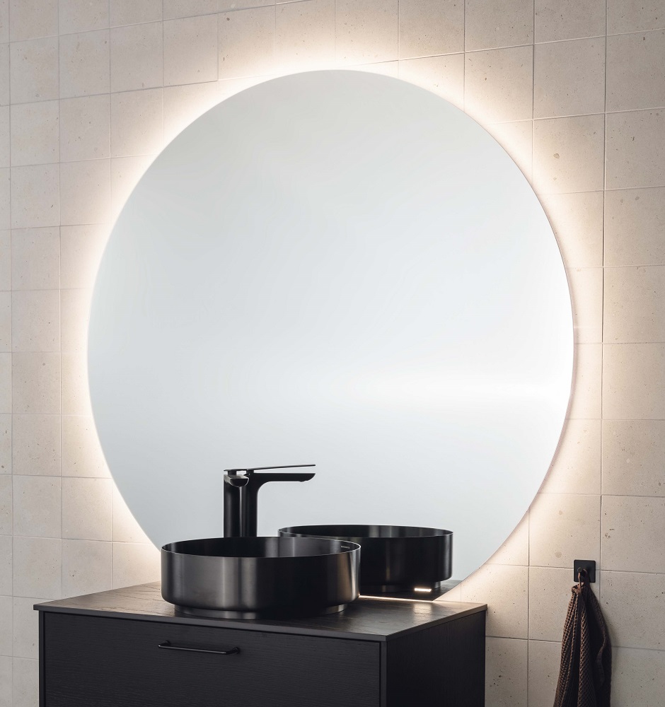 Pyöreät muodot ja mielenkiintoiset valaisuratkaisut tuovat kylpyhuoneeseen kauniin säväyksen. Kuvassa Valje-peili taustavalolla.

