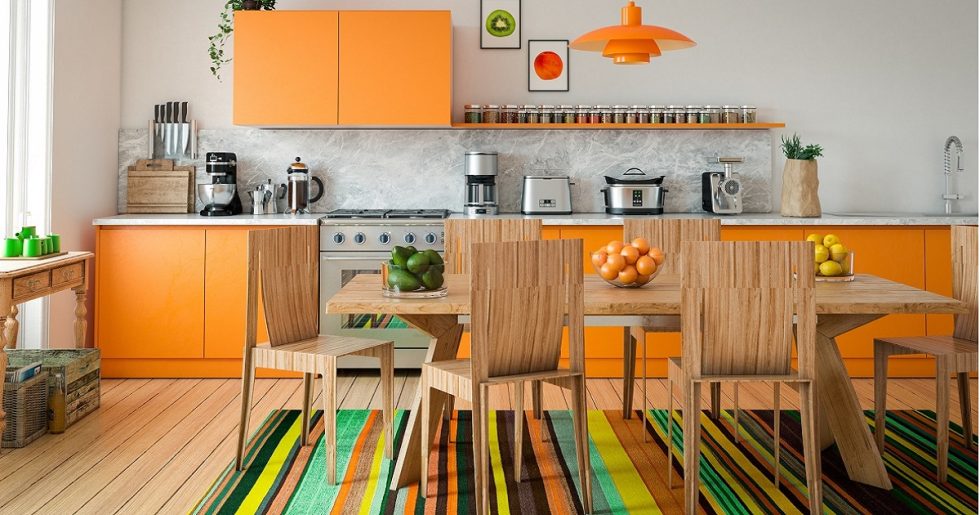 Värit luovat sisustuksen ilmeen. Värikäs matto ja oranssit kaapinovet.