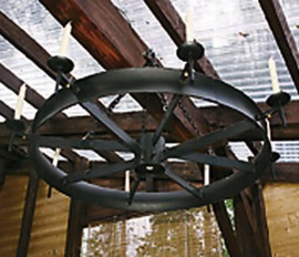 Jukka Kähönen teki kärrynpyörästä kattokruunun, joka valaisee joko kynttilöillä tai led-lampuilla.