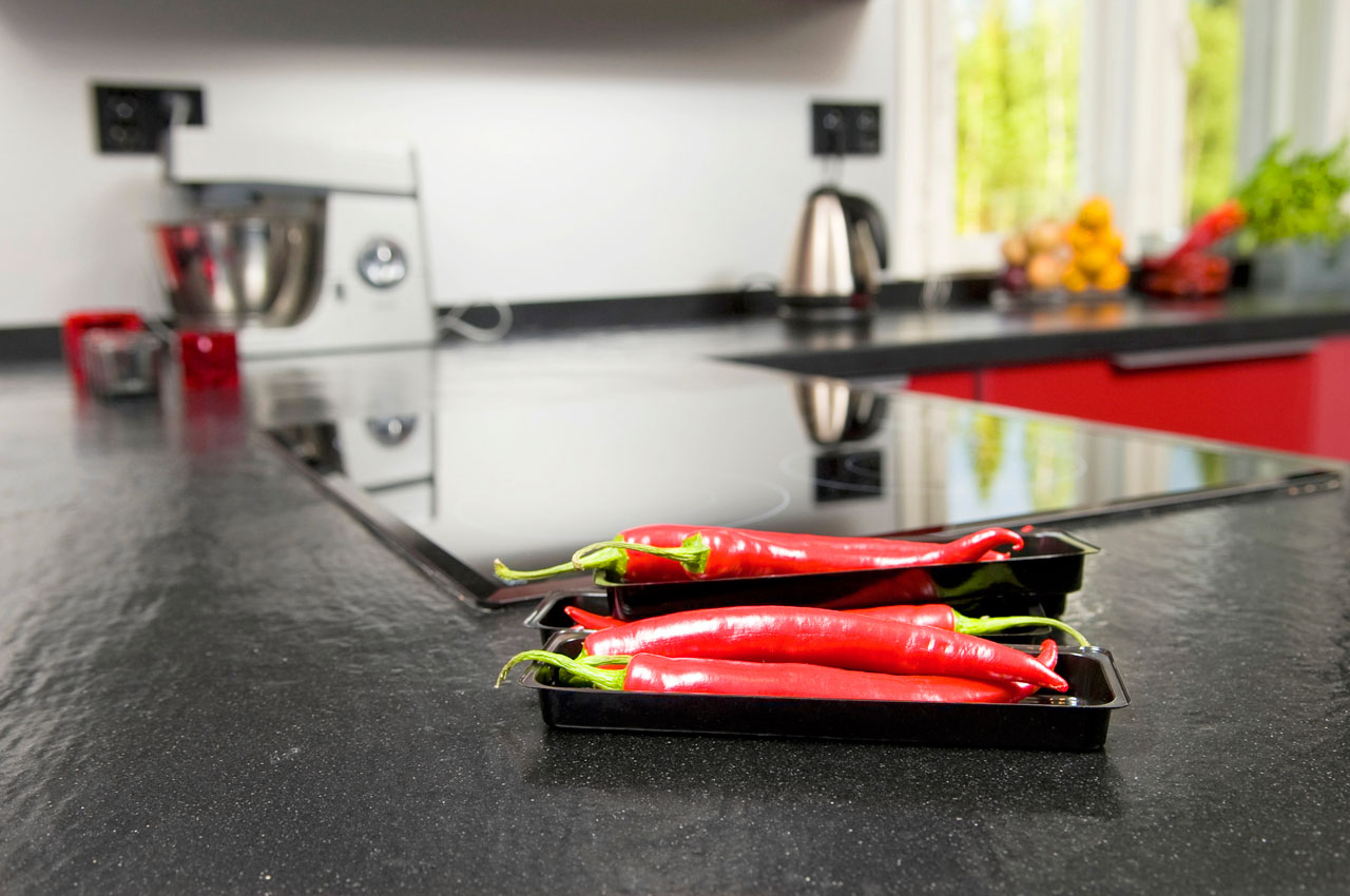 Keittiön mustaharmaat työtasot ovat kestävää, pestävää ja kolisematonta kvartsia.  